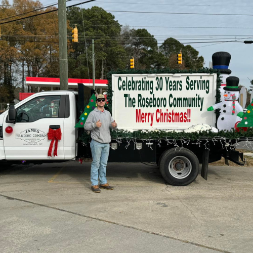 A decorated truck with a festive sign reading, 