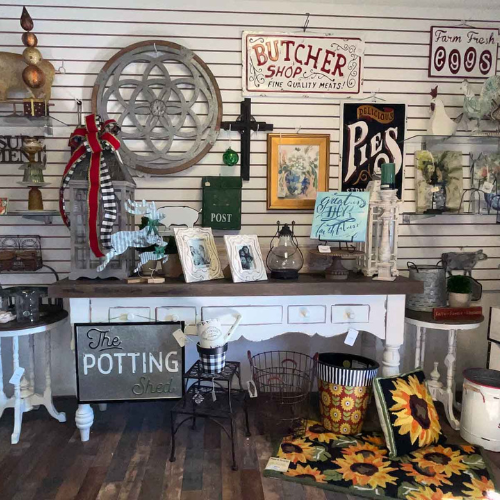 A vintage shop display with eclectic decor on white slat walls. Includes a 