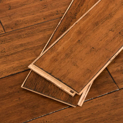 Close-up of three overlapping, rich brown bamboo flooring planks with dark grain patterns. The wood texture conveys a natural and warm tone.