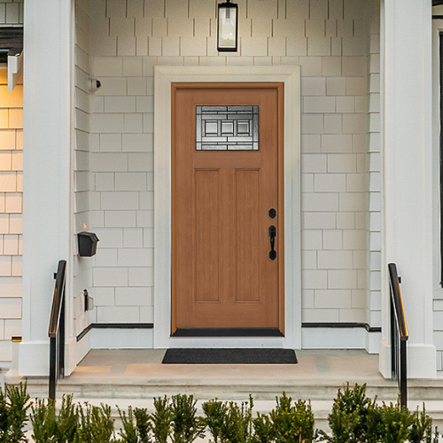 A wooden front door with a geometric glass panel is centered in a white brick entrance. Flanked by black railings, the porch exudes a welcoming and elegant tone.
