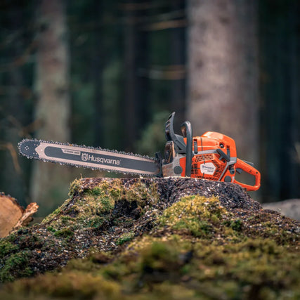 Outdoor Power EquipmentA Husqvarna chainsaw rests on a moss-covered tree stump in a dense forest, conveying a rugged and industrious tone with tall trees in the background.